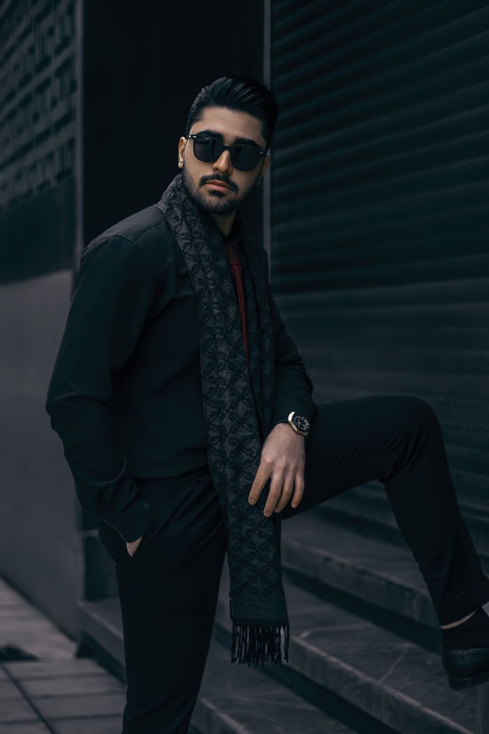 Crafting Captivating Headlines: Your awesome post title goes here Man in stylish attire posing confidently outdoors with a dark scarf and sunglasses.