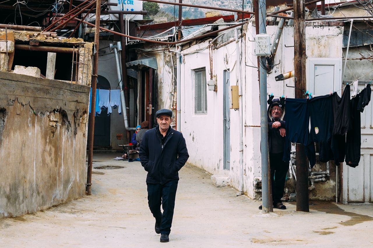 Services Two men in a rustic alleyway capture the essence of life in Baku.