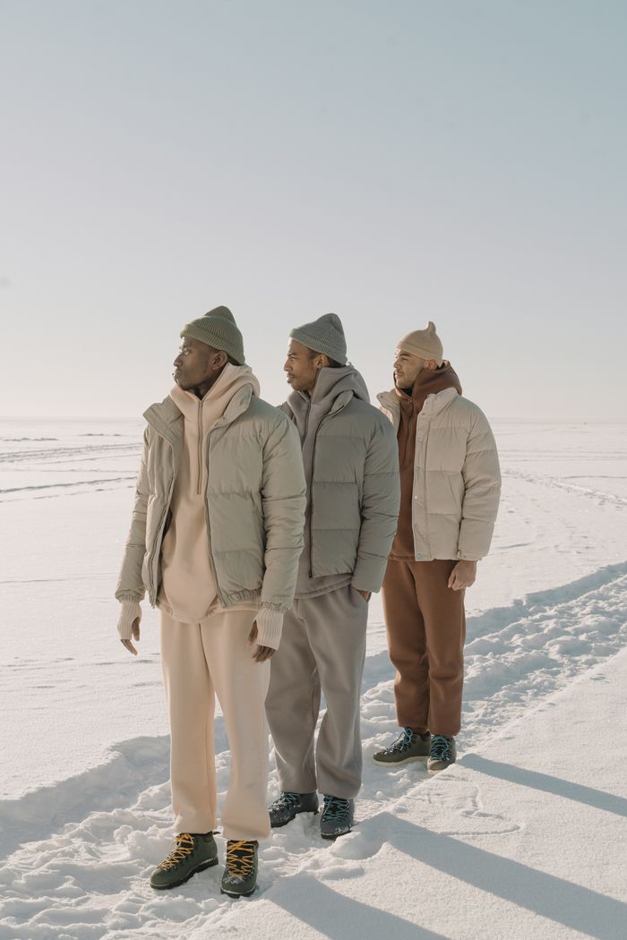 Mastering the First Impression: Your intriguing post title goes here Men in puffer jackets and beanies standing in a snowy landscape showcasing winter fashion.